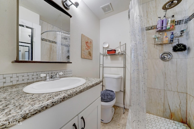 bathroom featuring visible vents, toilet, a tile shower, tile patterned flooring, and vanity