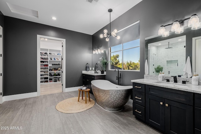 24905 S 206th Pl, Queen Creek, AZ 85142 - bathroom with a shower stall, vanity, a freestanding tub, a walk in closet, and baseboards