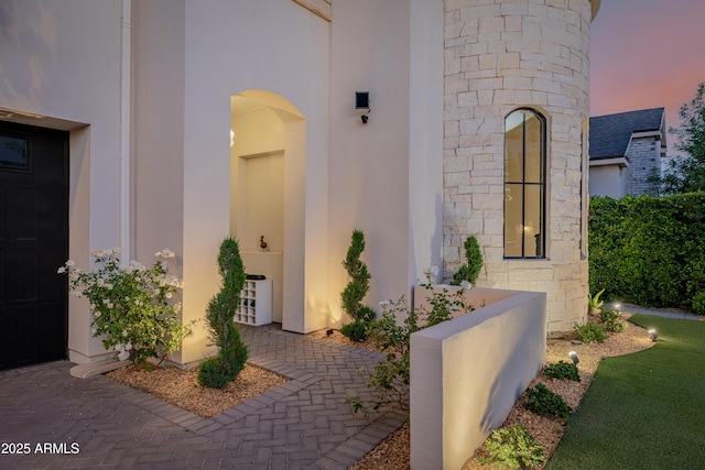 24905 S 206th Pl, Queen Creek, AZ 85142 - exterior entry at dusk featuring stone siding and stucco siding