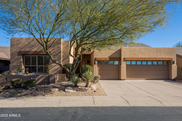 pueblo revival-style home featuring a garage