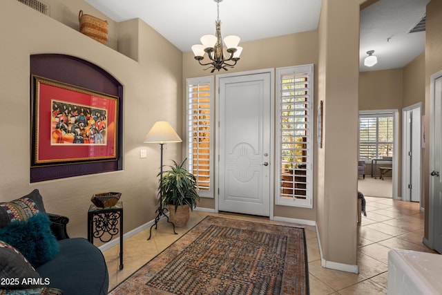 entrance foyer with light tile patterned floors and an inviting chandelier