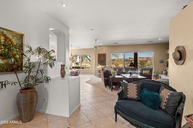 living room featuring ceiling fan, a wealth of natural light, and light tile patterned flooring