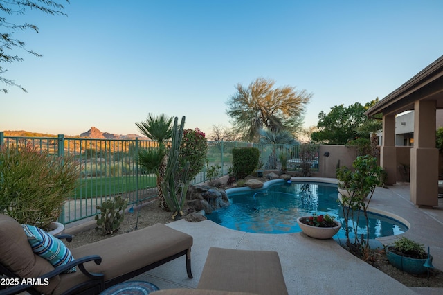 pool at dusk featuring a patio