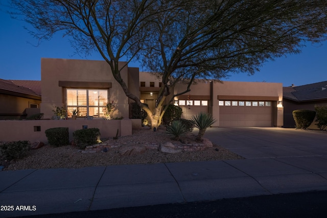 pueblo revival-style home with a garage