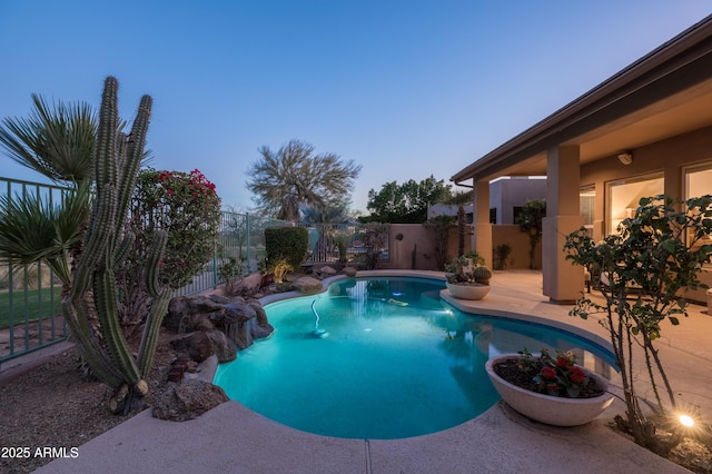 pool at dusk with a patio area