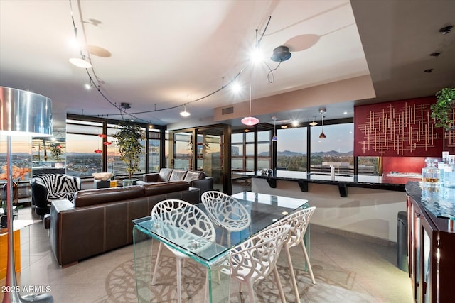 dining space with light tile patterned flooring, track lighting, and expansive windows