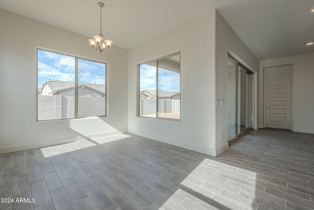 unfurnished dining area with light wood-type flooring and an inviting chandelier