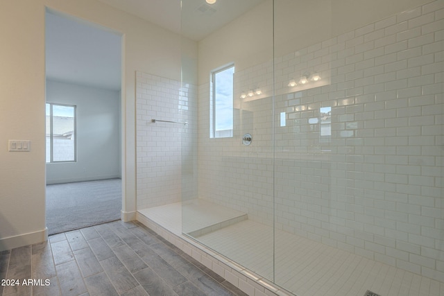 bathroom with hardwood / wood-style floors and tiled shower