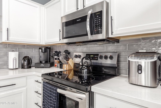 kitchen with white cabinetry, backsplash, and appliances with stainless steel finishes