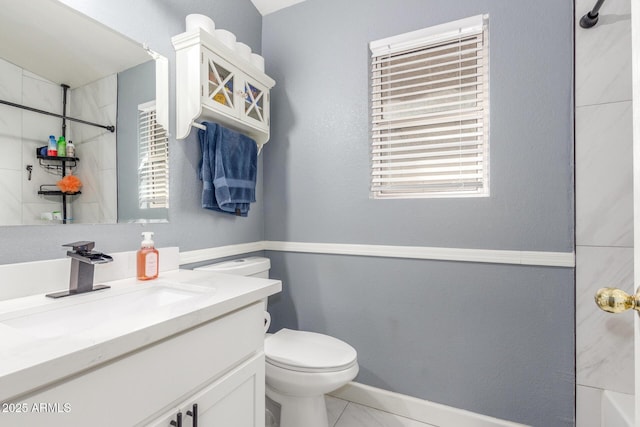 bathroom featuring vanity, a tile shower, and toilet