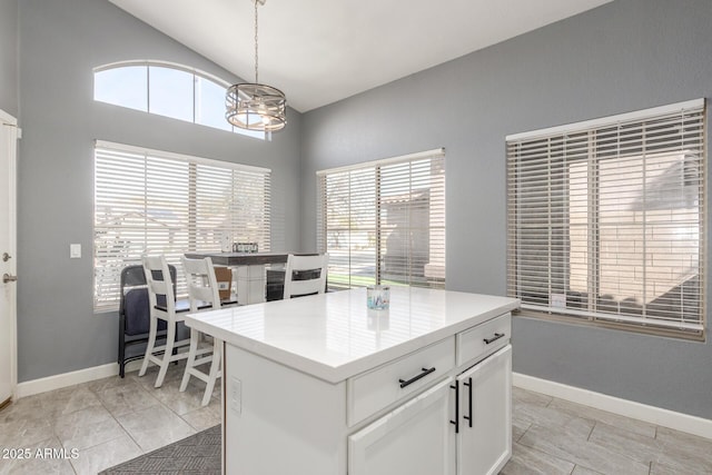 kitchen with white cabinetry, a healthy amount of sunlight, decorative light fixtures, and a center island