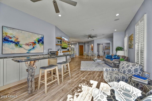 living room with ceiling fan and light wood-type flooring