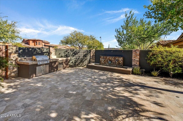 view of patio with area for grilling and a grill