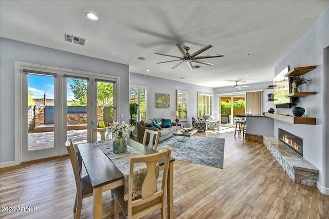 dining space with light hardwood / wood-style floors, a wealth of natural light, and ceiling fan