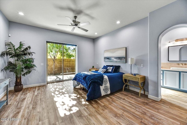 bedroom with light wood-type flooring, access to outside, ceiling fan, and connected bathroom