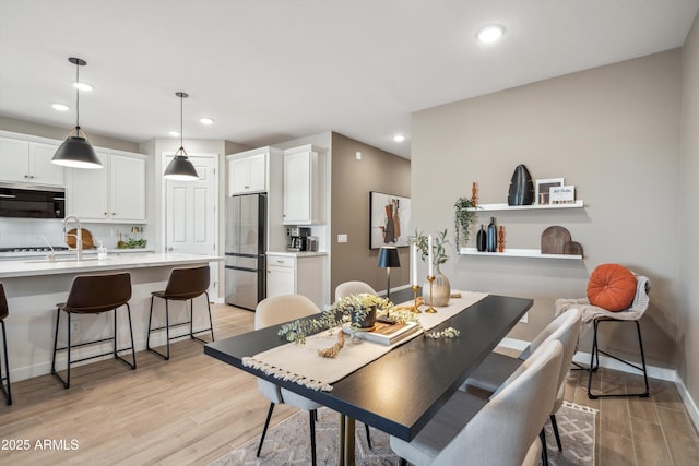 dining space with light hardwood / wood-style floors and sink