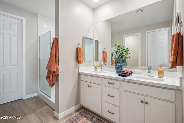 bathroom with hardwood / wood-style floors, vanity, and walk in shower