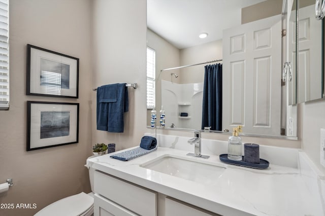 bathroom with a shower with shower curtain, vanity, and toilet