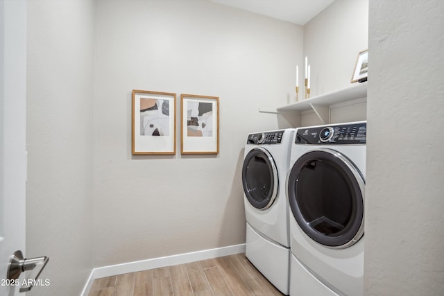 laundry room featuring washer and dryer and light hardwood / wood-style flooring