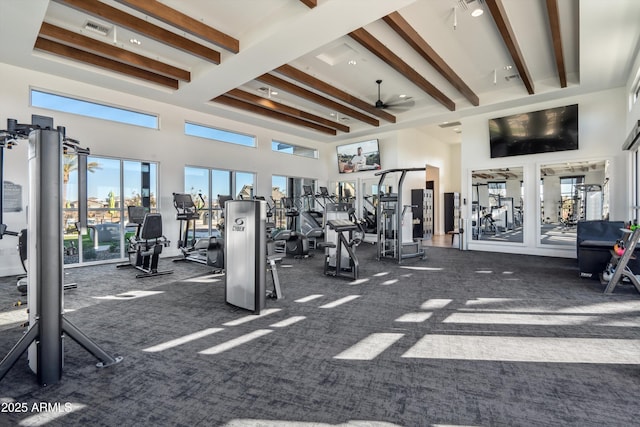 workout area with dark colored carpet, a towering ceiling, and ceiling fan