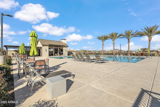 view of swimming pool featuring an outbuilding and a patio