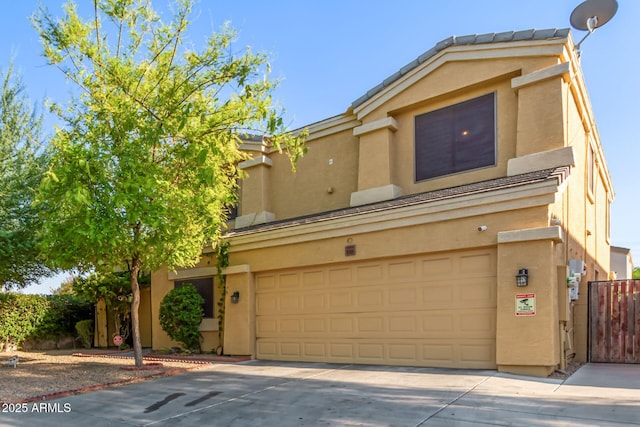 townhome / multi-family property featuring an attached garage, driveway, fence, and stucco siding