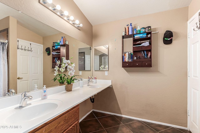 full bathroom featuring double vanity, tile patterned flooring, and a sink