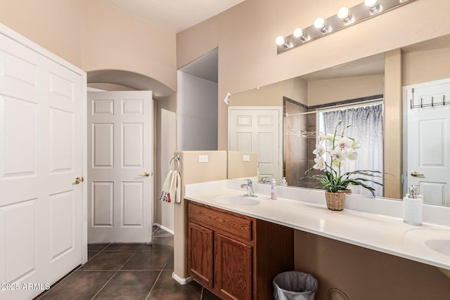 full bath featuring double vanity, a sink, and tile patterned floors