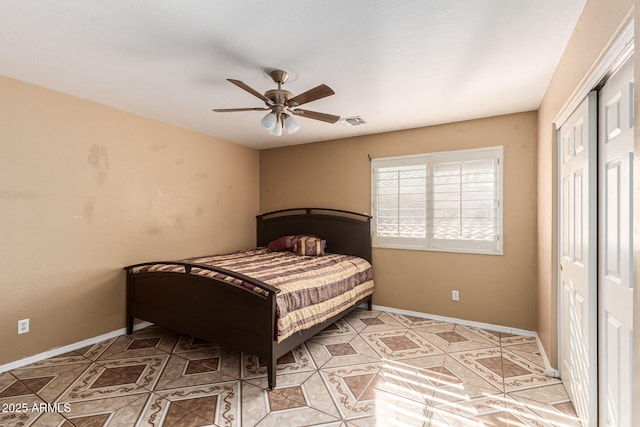 bedroom featuring baseboards, a ceiling fan, and light tile patterned flooring