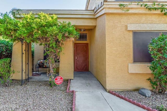 entrance to property featuring stucco siding