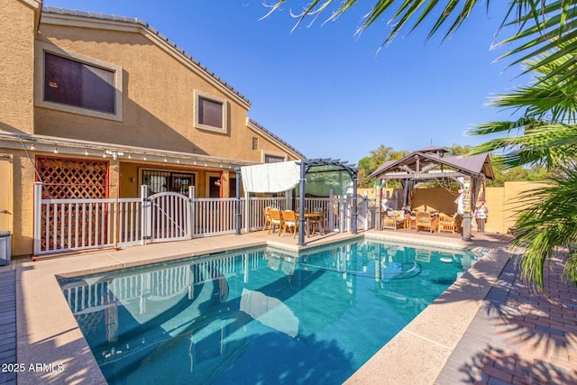 view of swimming pool with fence, a fenced in pool, and a gazebo