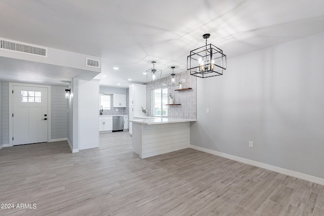 kitchen featuring dishwasher, kitchen peninsula, white cabinets, and light hardwood / wood-style floors