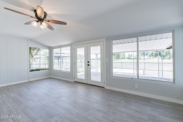 unfurnished room featuring french doors, lofted ceiling, light hardwood / wood-style flooring, and ceiling fan