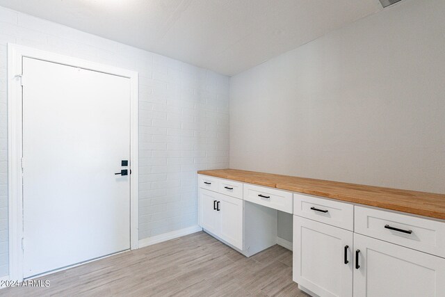 interior space with built in desk and light hardwood / wood-style floors