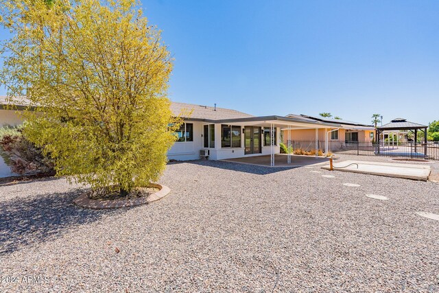 back of property featuring a gazebo and a patio