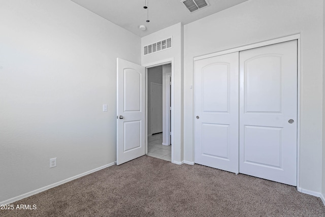 unfurnished bedroom featuring light colored carpet and a closet