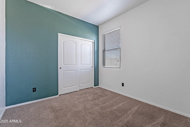 unfurnished bedroom featuring a closet and carpet flooring