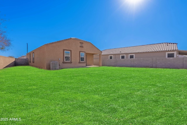 back of property featuring central AC unit and a lawn