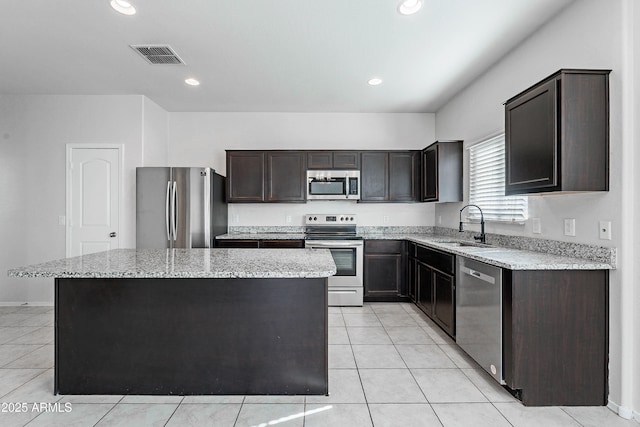 kitchen with dark brown cabinetry, sink, a center island, and appliances with stainless steel finishes