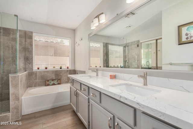 1653 E Gail Dr, Chandler, AZ 85225 - bathroom featuring double vanity, a garden tub, wood finished floors, and a stall shower