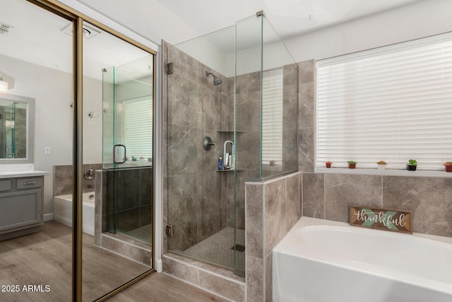 1653 E Gail Dr, Chandler, AZ 85225 - full bathroom featuring vanity, a garden tub, wood finished floors, and a shower stall