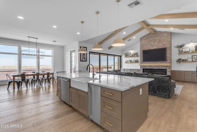 kitchen with decorative light fixtures, dishwasher, sink, a center island with sink, and light hardwood / wood-style flooring