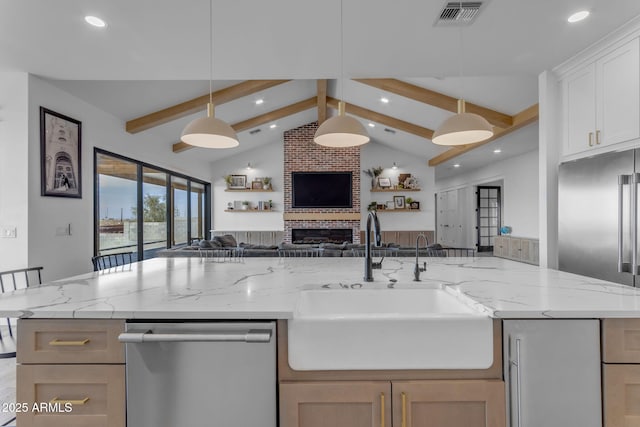 kitchen with sink, white cabinetry, light stone counters, dishwasher, and pendant lighting