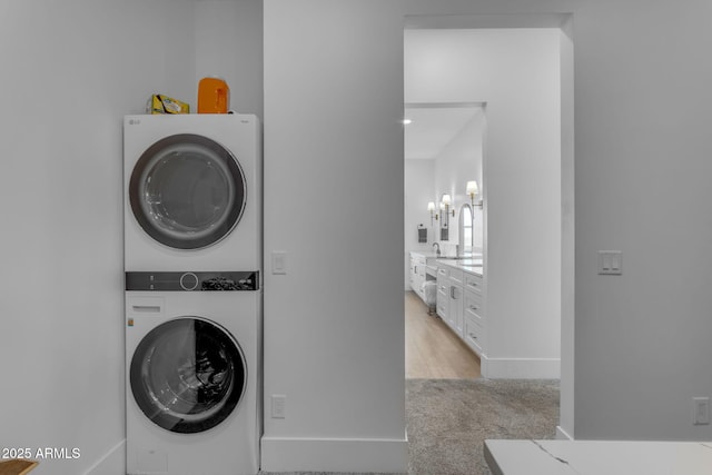 washroom featuring light colored carpet and stacked washer and clothes dryer