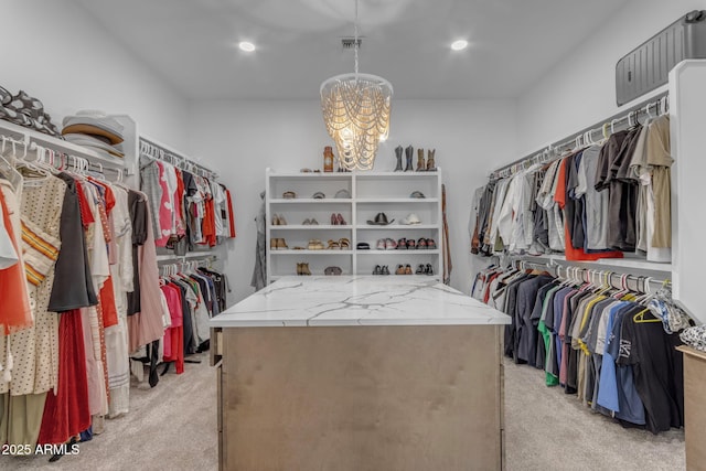 walk in closet featuring light colored carpet and a notable chandelier