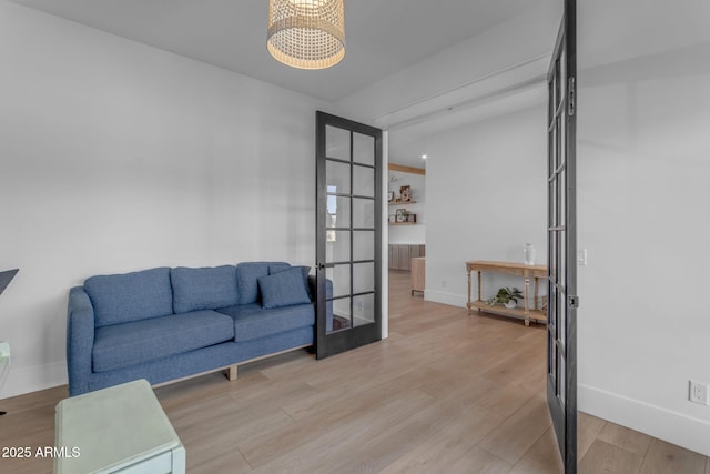 interior space with an inviting chandelier, light hardwood / wood-style floors, and french doors