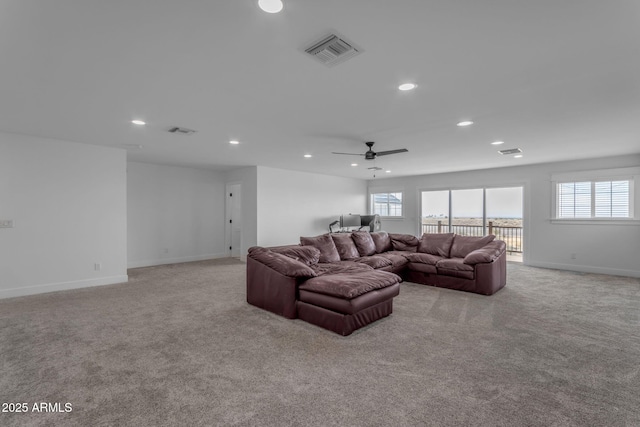 carpeted living room with ceiling fan