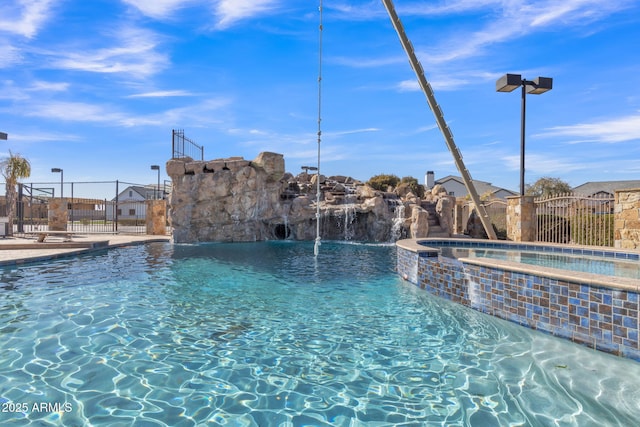 view of pool featuring pool water feature and an in ground hot tub