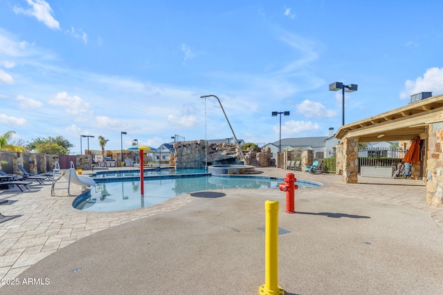 view of pool with a hot tub and a patio