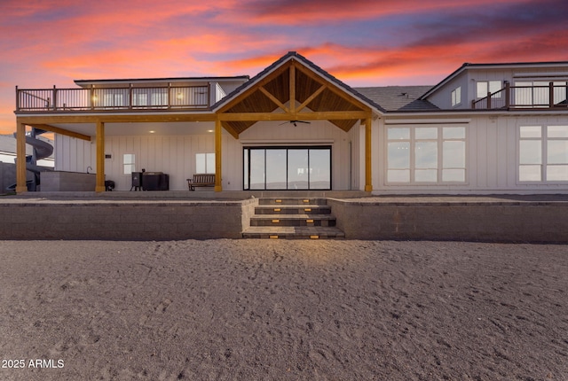 back house at dusk featuring ceiling fan